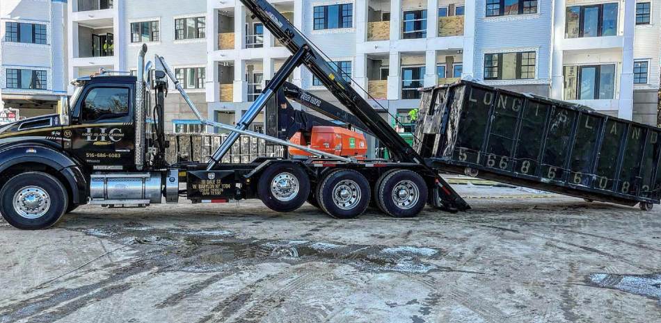 black and platinum trailer picking up a black dumpster