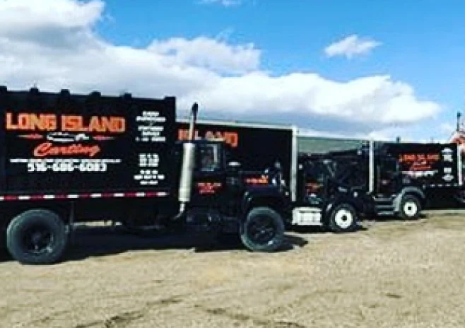 black dumpsters on the middle of a field