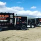 black dumpsters on the middle of a field